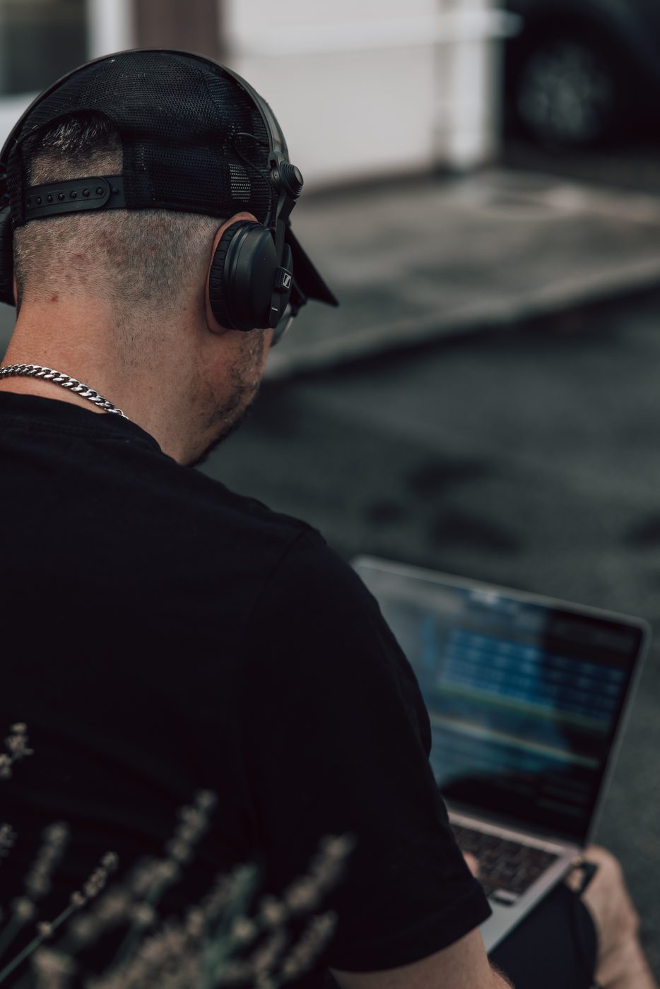 Vaynex outside with headphones on, laptop in hand